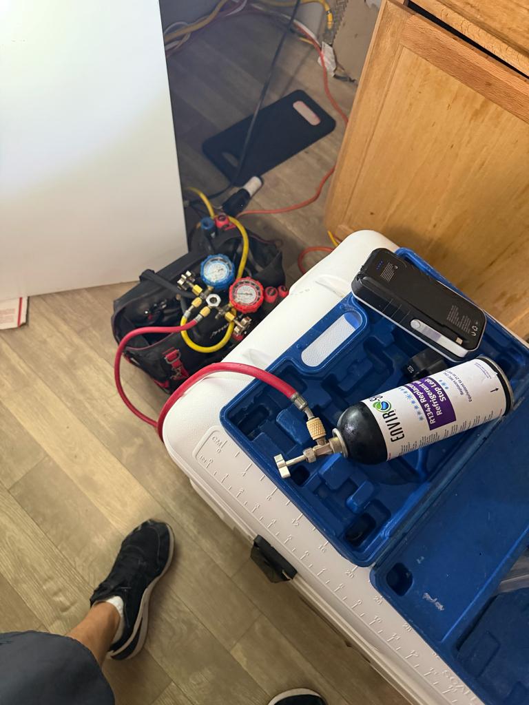 Manifold gauges and R-134a used to check a Kenmore refrigerator for a refrigerant leak
