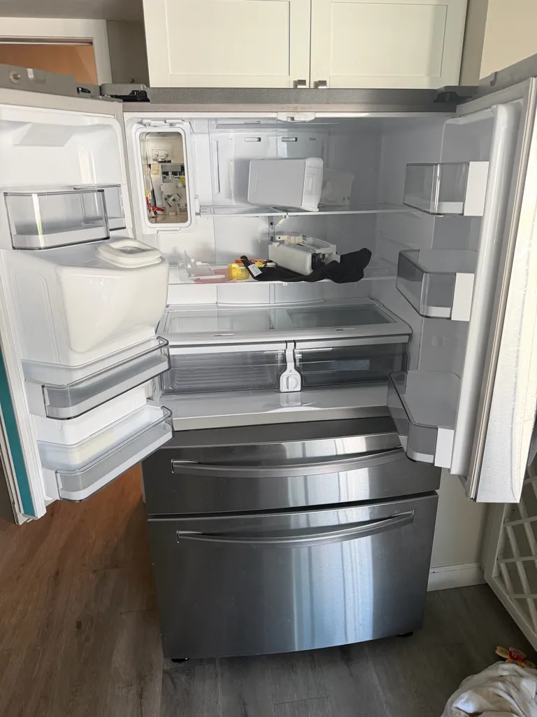 Samsung RF24R7201SR four-door refrigerator emptied with both upper doors open, ice maker compartment at the top left, Old Coach Trail, Clearwater, FL