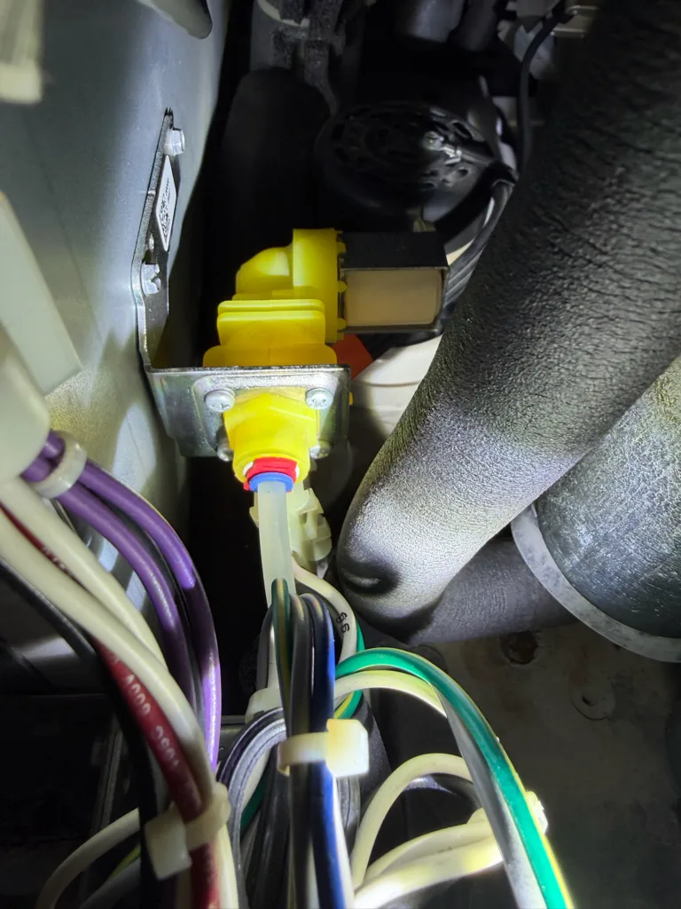 Yellow water inlet valve mounted inside a commercial ice machine