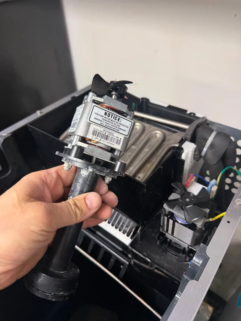Circulation pump of a Scotsman ice machine held in a technician's hand